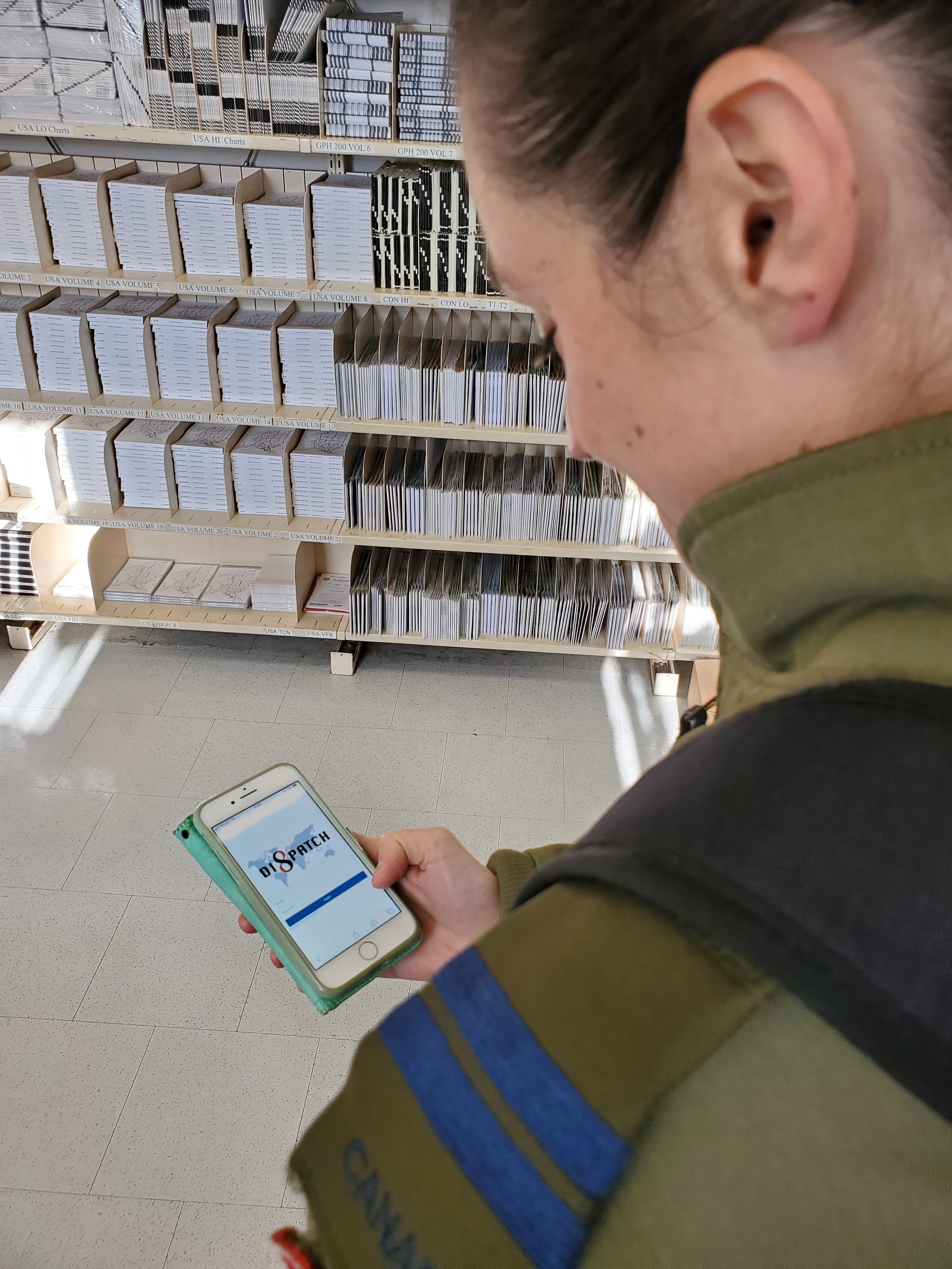 Captain Amanda Whalen, of 424 (Transport & Rescue) Squadron, 8 Wing, uses her cellphone to log into Dispatch, demonstrating the easy accessibility of its modern software design. 