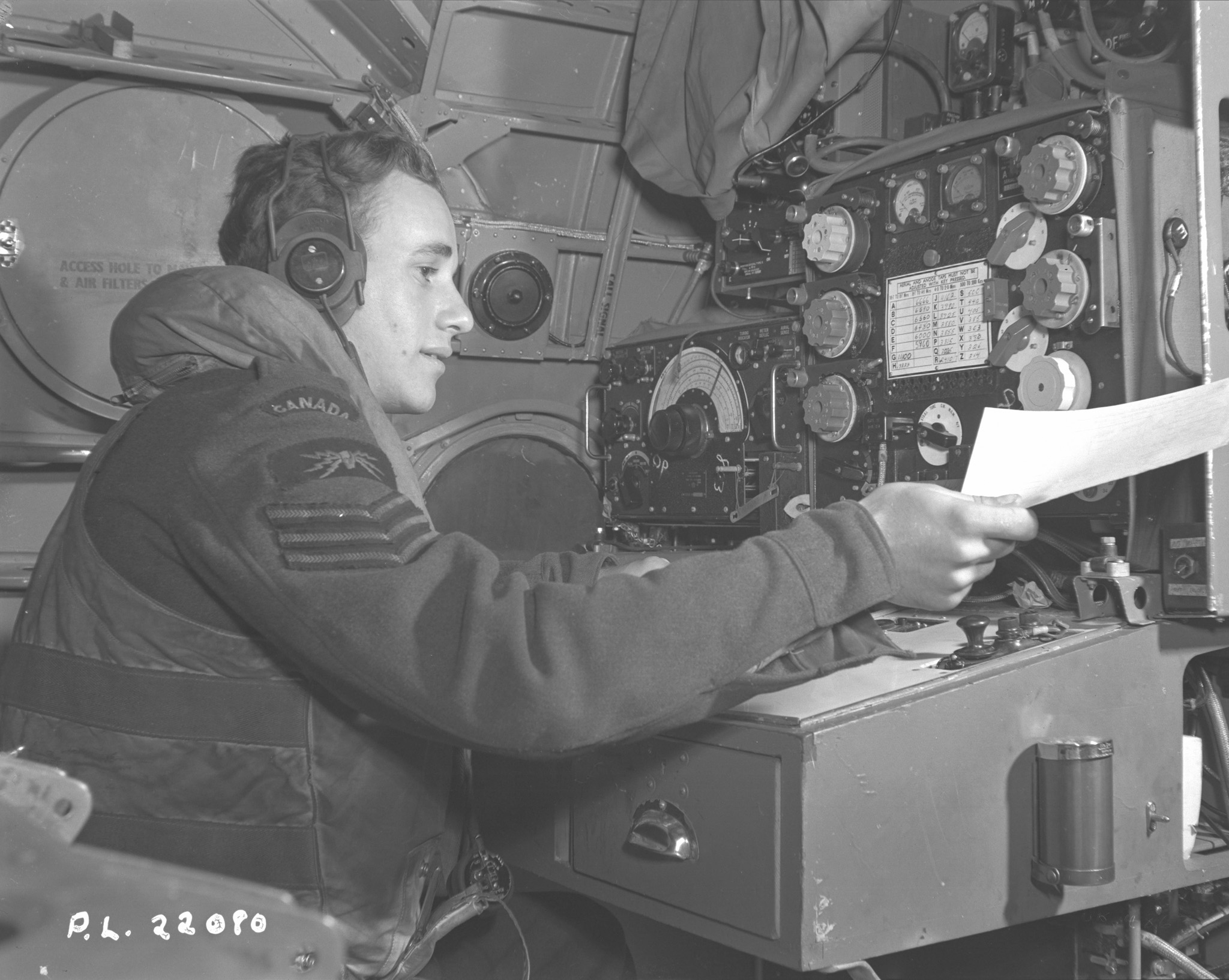 Sergeant L.J. Irving, a wireless operator onboard a Sunderland flying boat from the RCAF’s 423 Squadron, part of Coastal Command, hands a message to his skipper during an anti-submarine patrol. PHOTO: DND Archives, PL-22080